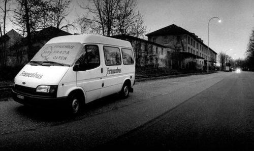 Schwarz-Weiss-Foto: Der weisse Lieferwagen «Frauenbus Lysistrada Olten» steht in der Dämmerung am Strassenrand.